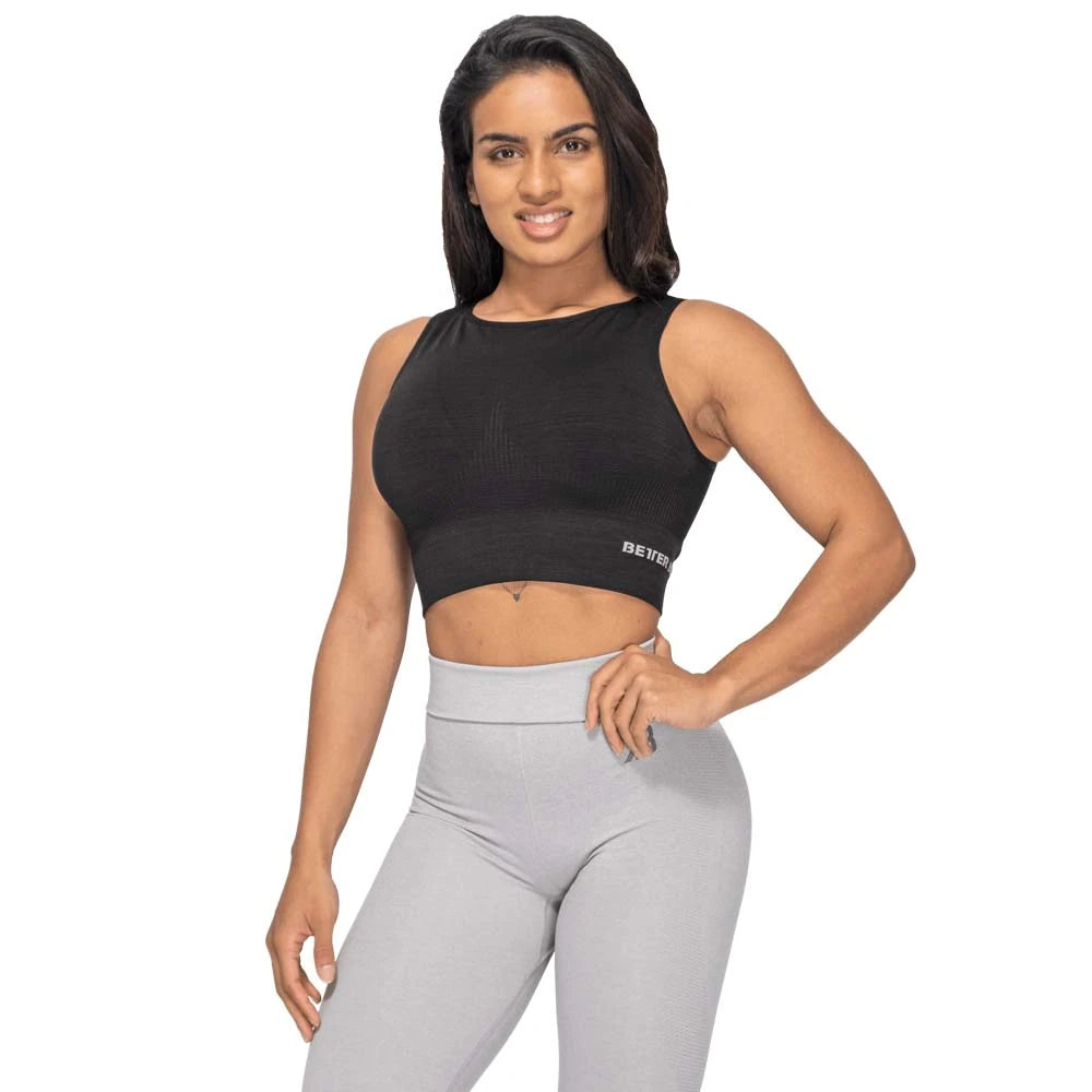 Kvinne i Better Bodies Rib Seamless Top Black Melange, en svart og sømløs crop top for trening.
