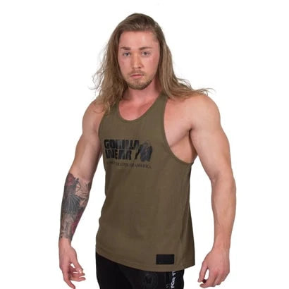 Gorilla Wear Classic Tank Top Army Green, en klassisk brytersinglet i bomull med svart logo båret av en mannlig modell., bilde 4 av 5