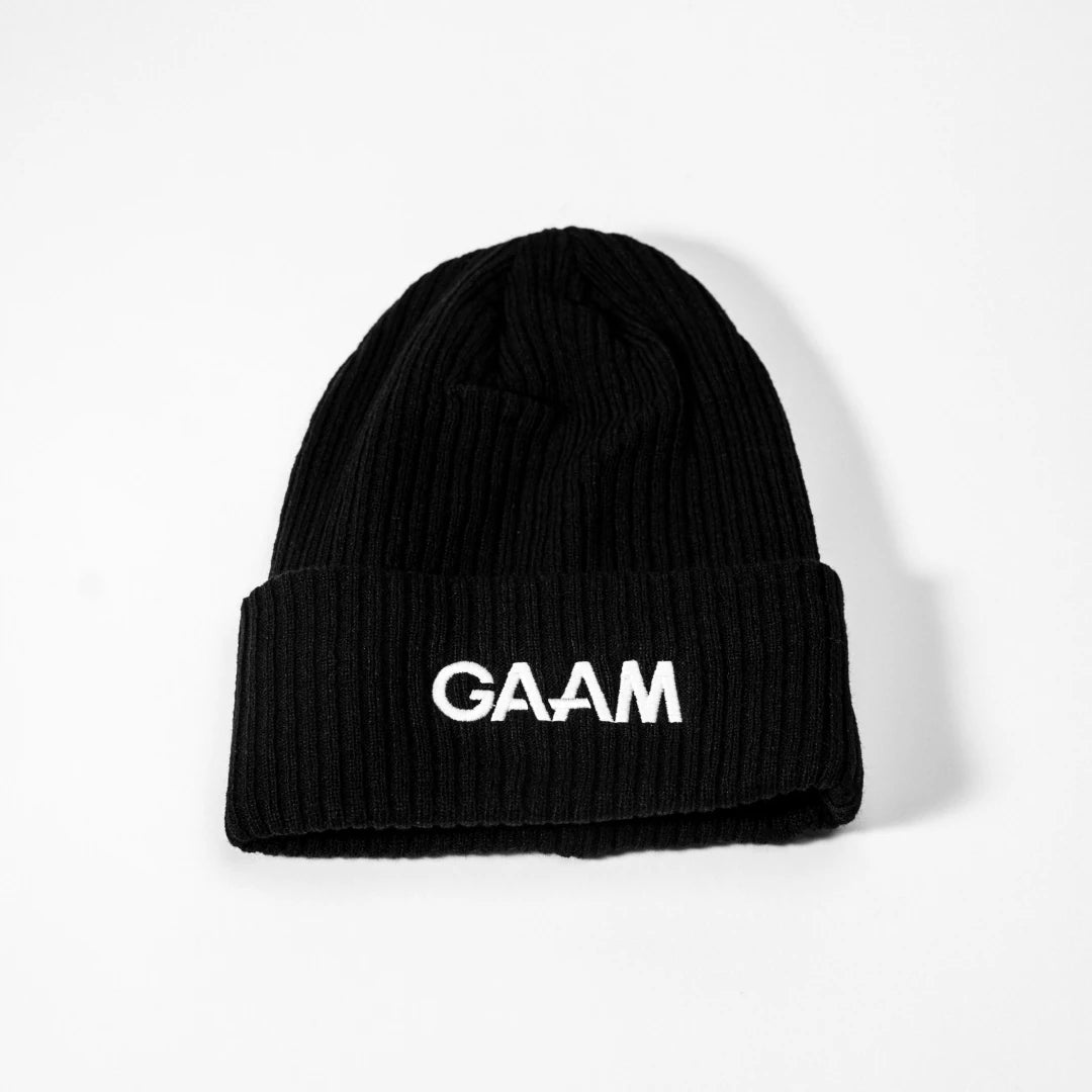GAAM Beanie Black, en svart ribbestrikket lue med oppbrettet kant og tydelig hvit logo foran.