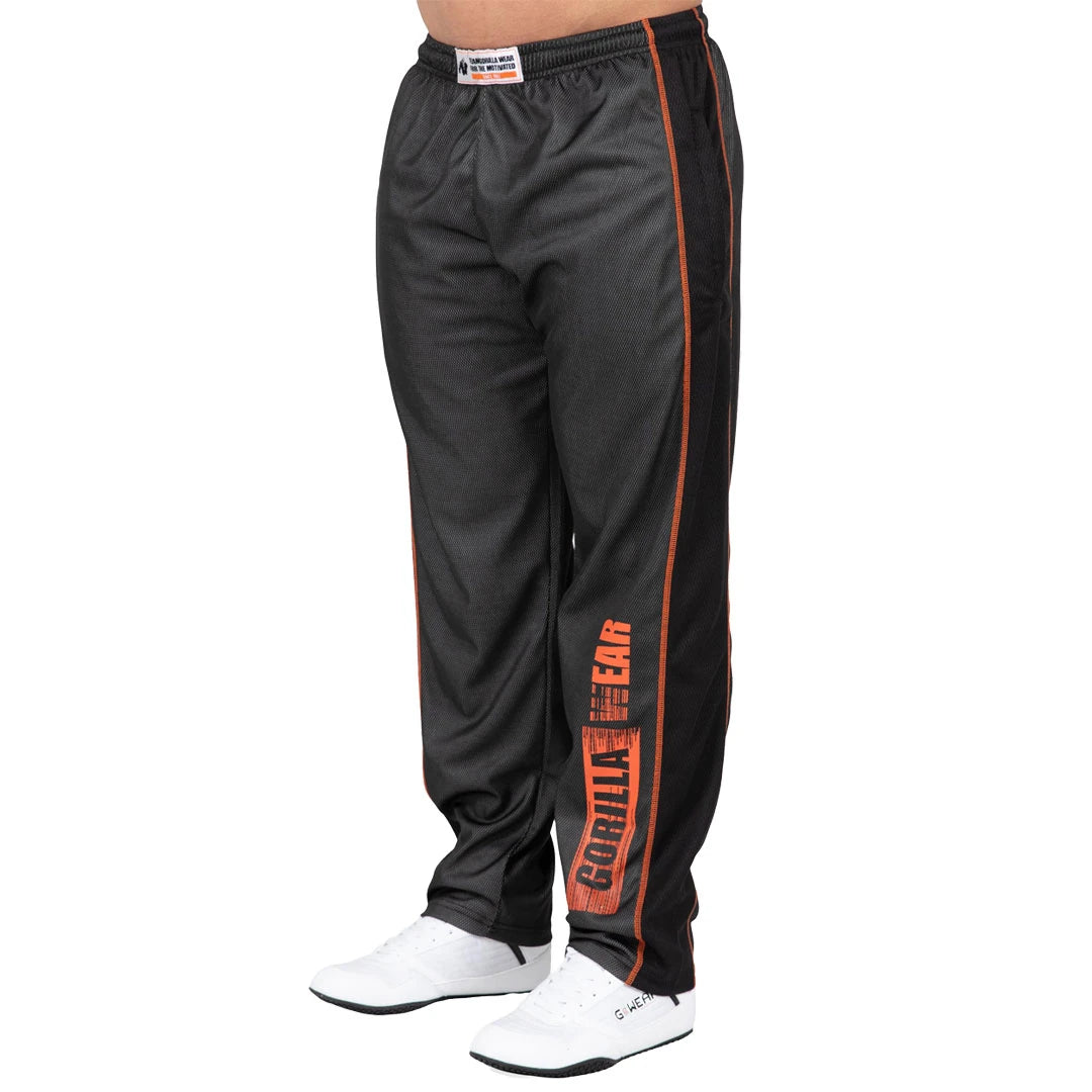 Gorilla Wear Wallace Mesh Pants Grey/Orange, grå treningsbukser i mesh med løs passform og oransje logo på benet., bilde 2 av 4