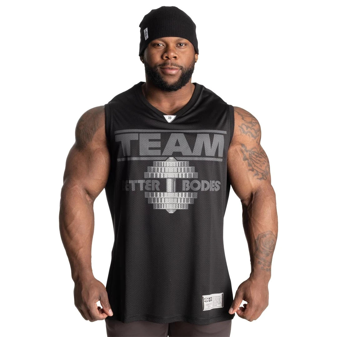 Better Bodies Iron Mesh Tank Black, en svart treningstopp i mesh med stort brysttrykk båret av en mann.