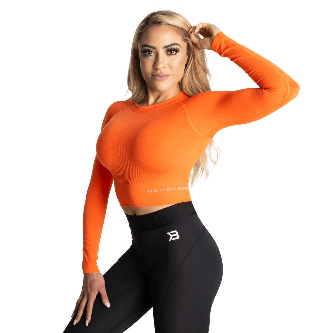 Oransje Better Bodies Rib Seamless Crop LS Sunset Melange, en langermet og ribbet crop-top båret av en modell., bilde 2 av 2