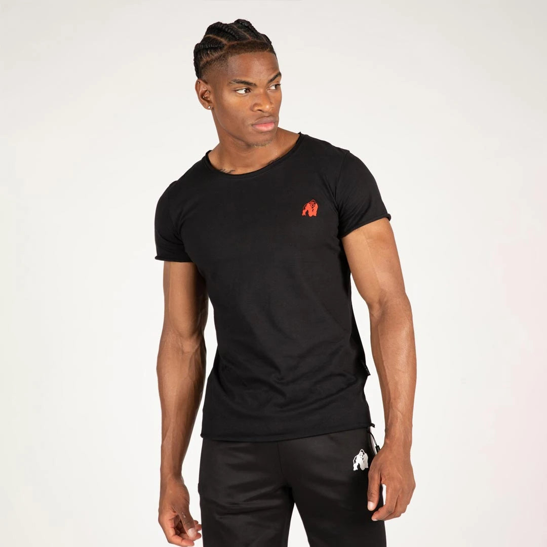 Mann iført Gorilla Wear York T-Shirt Black i myk bomull med rød logo, slim fit og rå kanter.