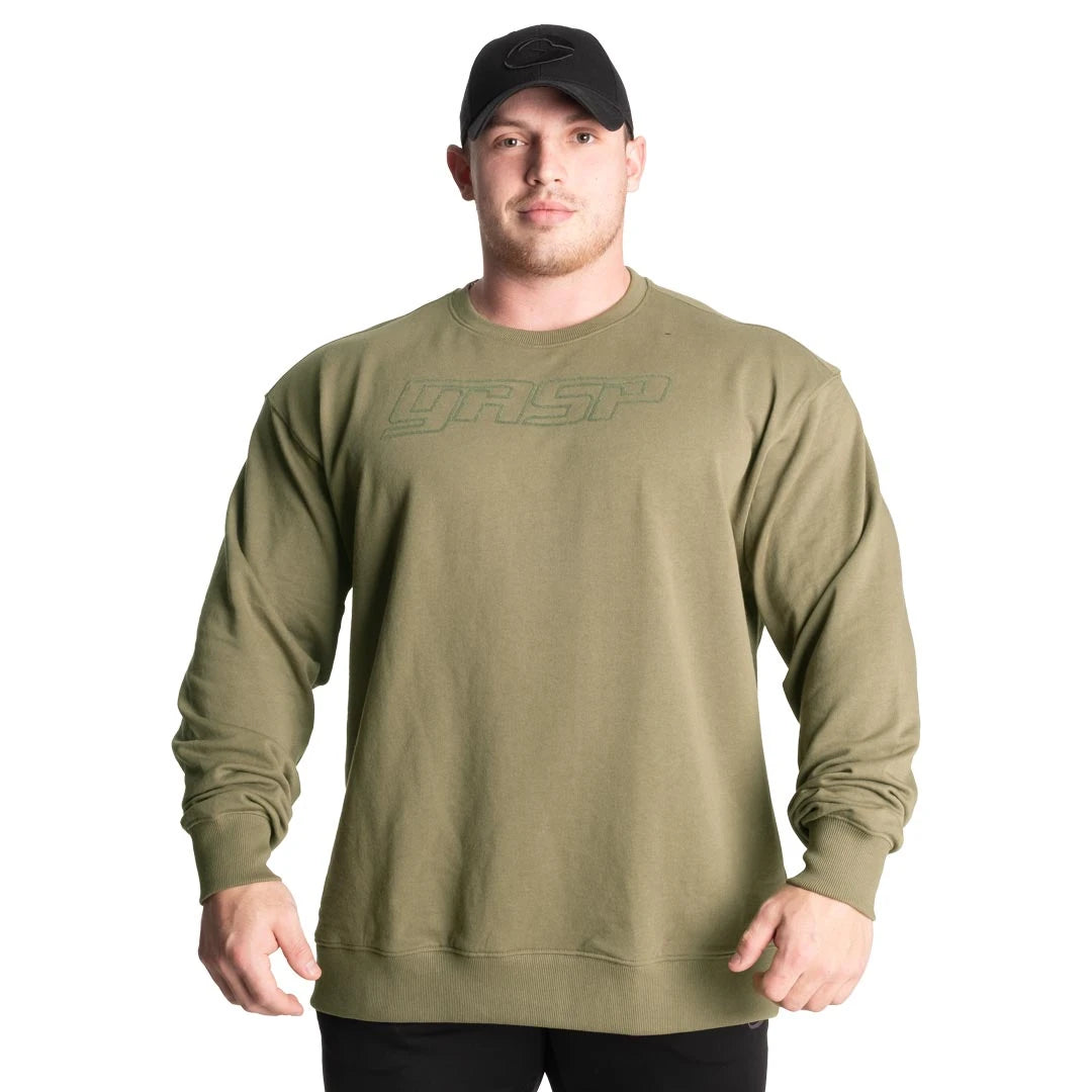GASP Division Crewneck Washed Green er en grønn sweatshirt i jerseymateriale med opphøyd brystlogo, båret av en mann., bilde 2 av 2