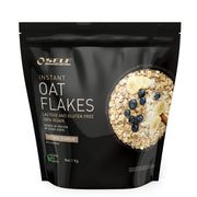 Self Omninutrition Instant Oat Flakes 1 kg förpackad i en svart påse med motiv av en skål havregryn och bär.