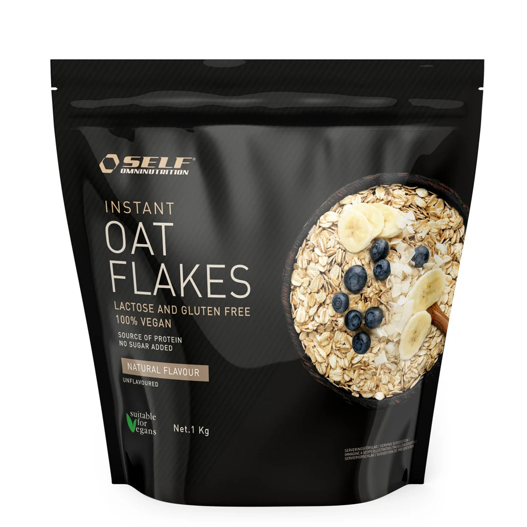 Self Omninutrition Instant Oat Flakes 1 kg pakket i en svart pose med motiv av en skål havregryn og bær.
