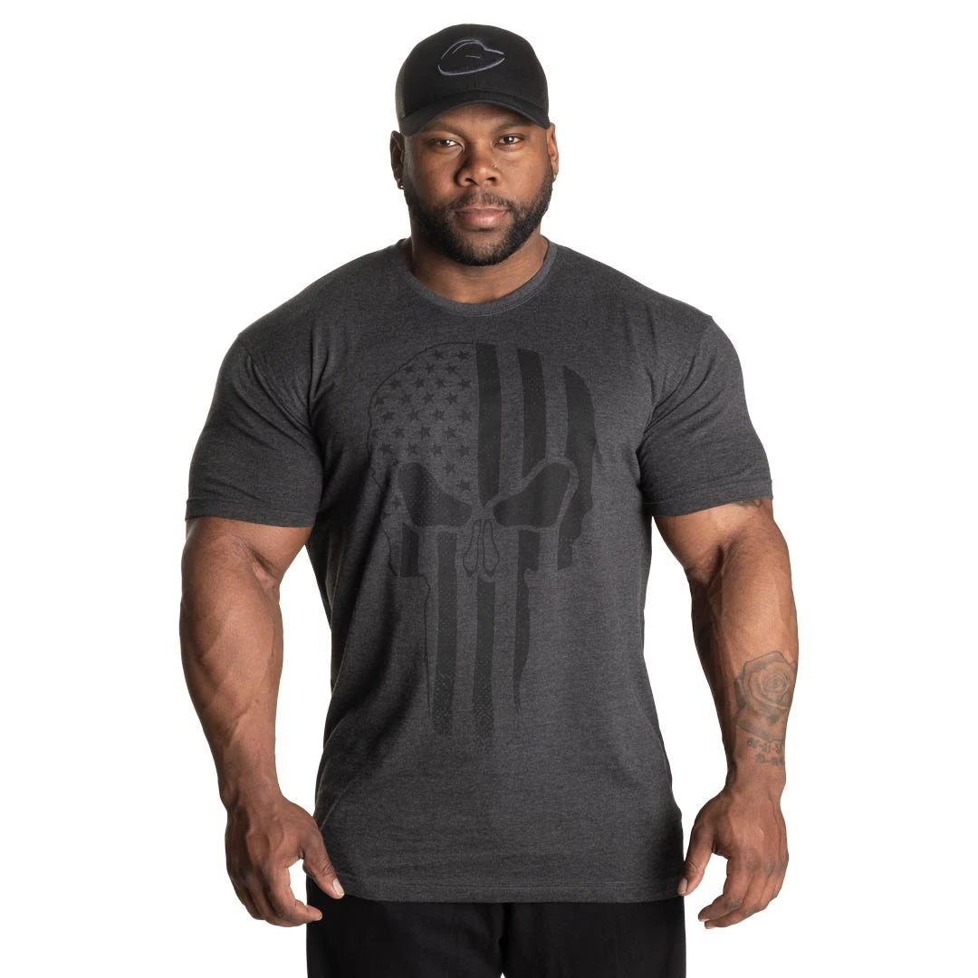 GASP Skull Standard Tee Dark Grey Melange, en mørkegrå t-skjorte med et stort hodeskalletrykk, båret av en modell., bilde 4 av 8