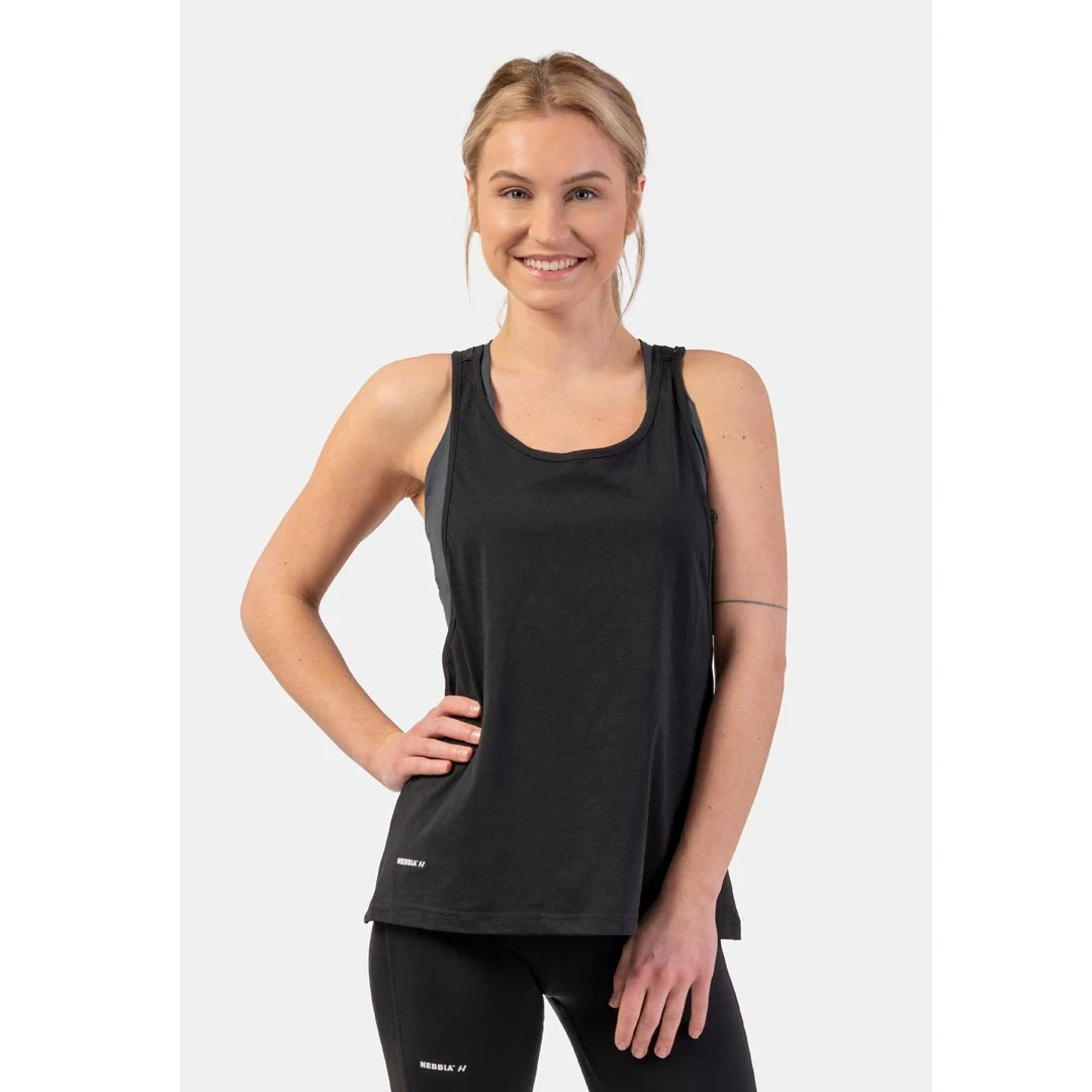 NEBBIA Sleeveless Loose Cross Back Tank Top Feeling Good Black, en løs, svart treningstopp i bomull båret av en modell.
