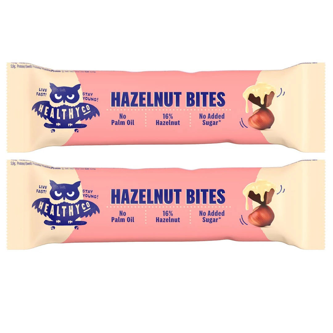 Healthyco Hazelnut Bites 21 g x 2 st i to rosa forpakninger med mørkeblå tekst og en illustrert hasselnøtt.