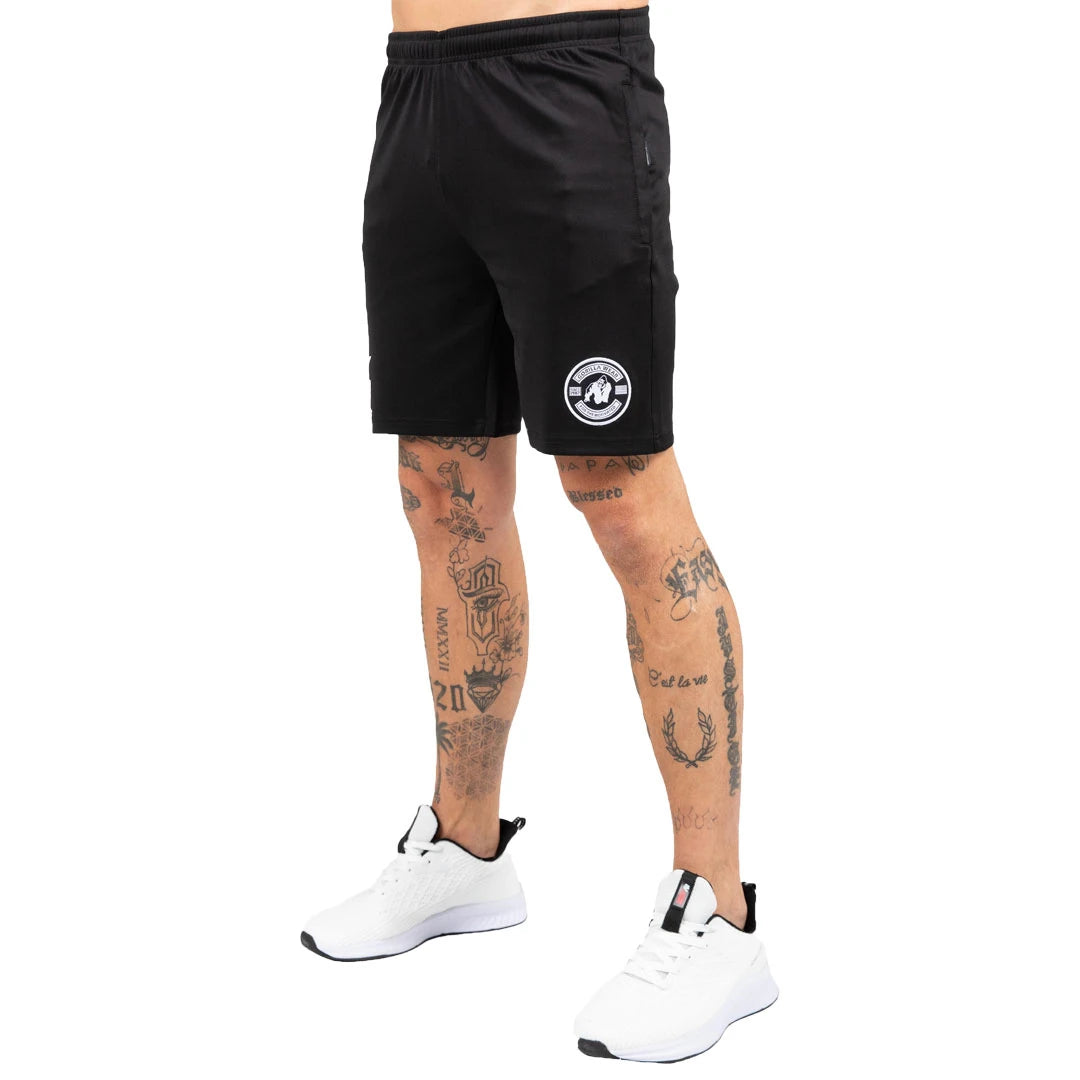 Gorilla Wear Vernon Track Shorts Black, svarte treningsshorts med hvit logo vist på en tatovert modell., bilde 2 av 7