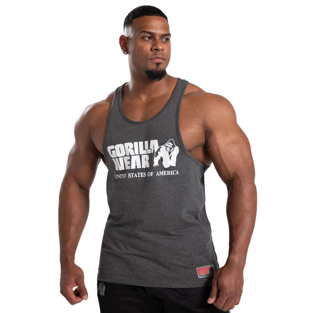 Mann i Gorilla Wear Classic Tank Top Dark Grey, en brytetrøye i bomull med stort hvitt logotrykk foran., bilde 4 av 7