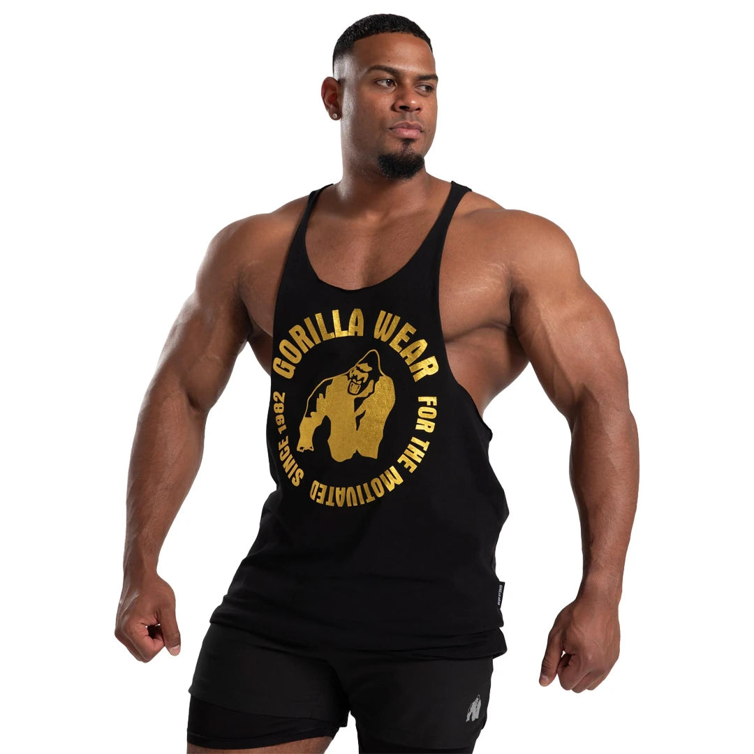 Gorilla Wear Melrose Stringer Black Gold, en svart treningssinglet med stort gulltrykk båret av en muskuløs modell., bilde 6 av 7