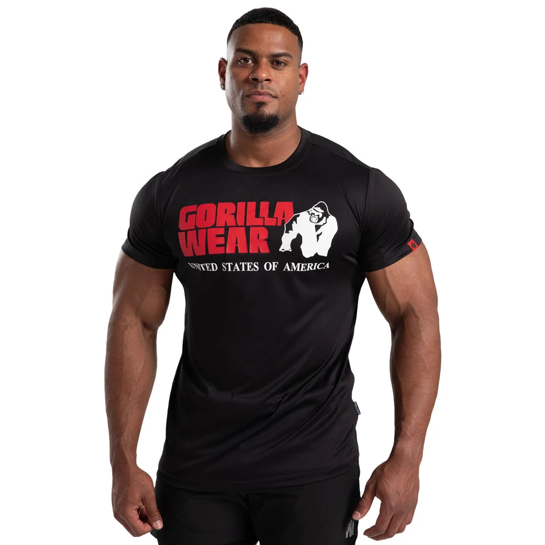 Mann iført Gorilla Wear Classic Training T-Shirt Black, en svart trenings-t-skjorte med stor rød logo på brystet., bilde 4 av 7