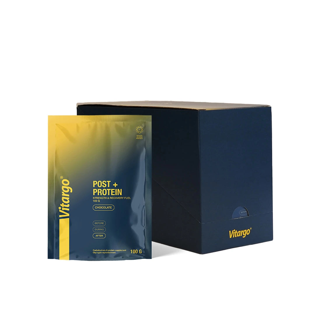 Vitargo Post Protein 15 x 100 g sjokolade, mørkeblå og gul porsjonspose stående ved siden av en mørkeblå kartong.