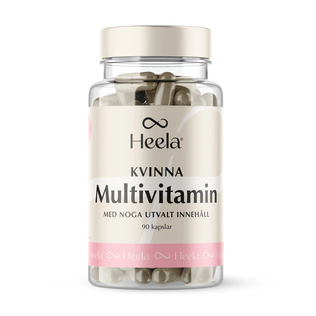 Heela Multivitamin Woman 60 caps i en gjennomsiktig boks med lyst lokk og en beige etikett med rosa detaljer.