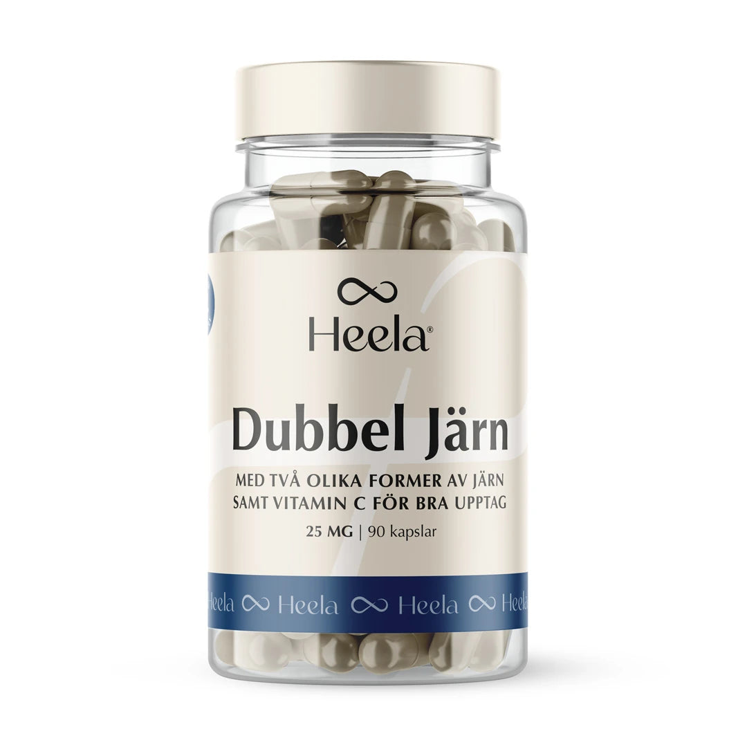 Heela Dubbel Järn 25 mg 90 caps kosttilskudd i en gjennomsiktig plastboks med beige og blå etikett, fylt med kapsler.