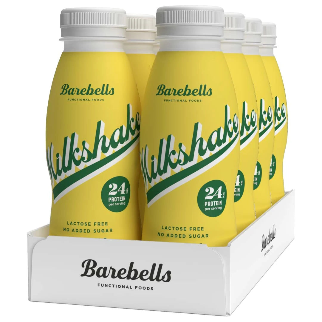 8 x Barebells Milkshake 330 ml Banana i gule flasker med grønn tekst samlet i et hvitt brett.