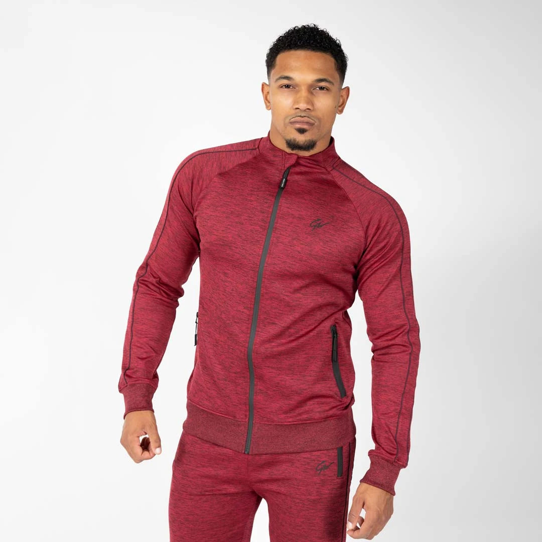 Gorilla Wear Wenden Track Jacket Burgundy Red, en stretchy vinrød treningsjakke med svarte detaljer båret av en modell.