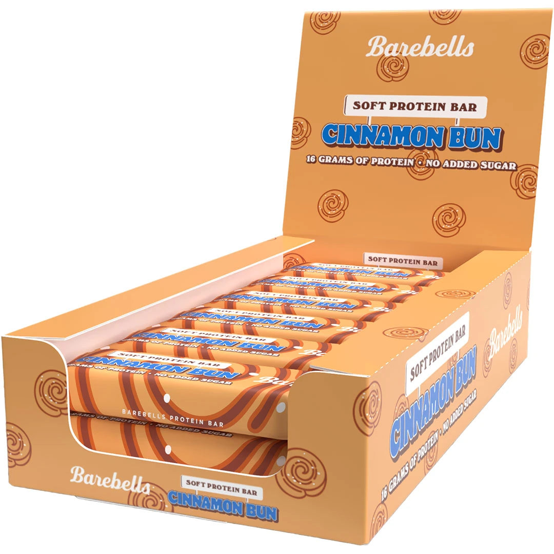 12 x Barebells Soft Bar 55 g Cinnamon Bun i en oransjebrun displayeske med kanelbollemønster og blå detaljer.