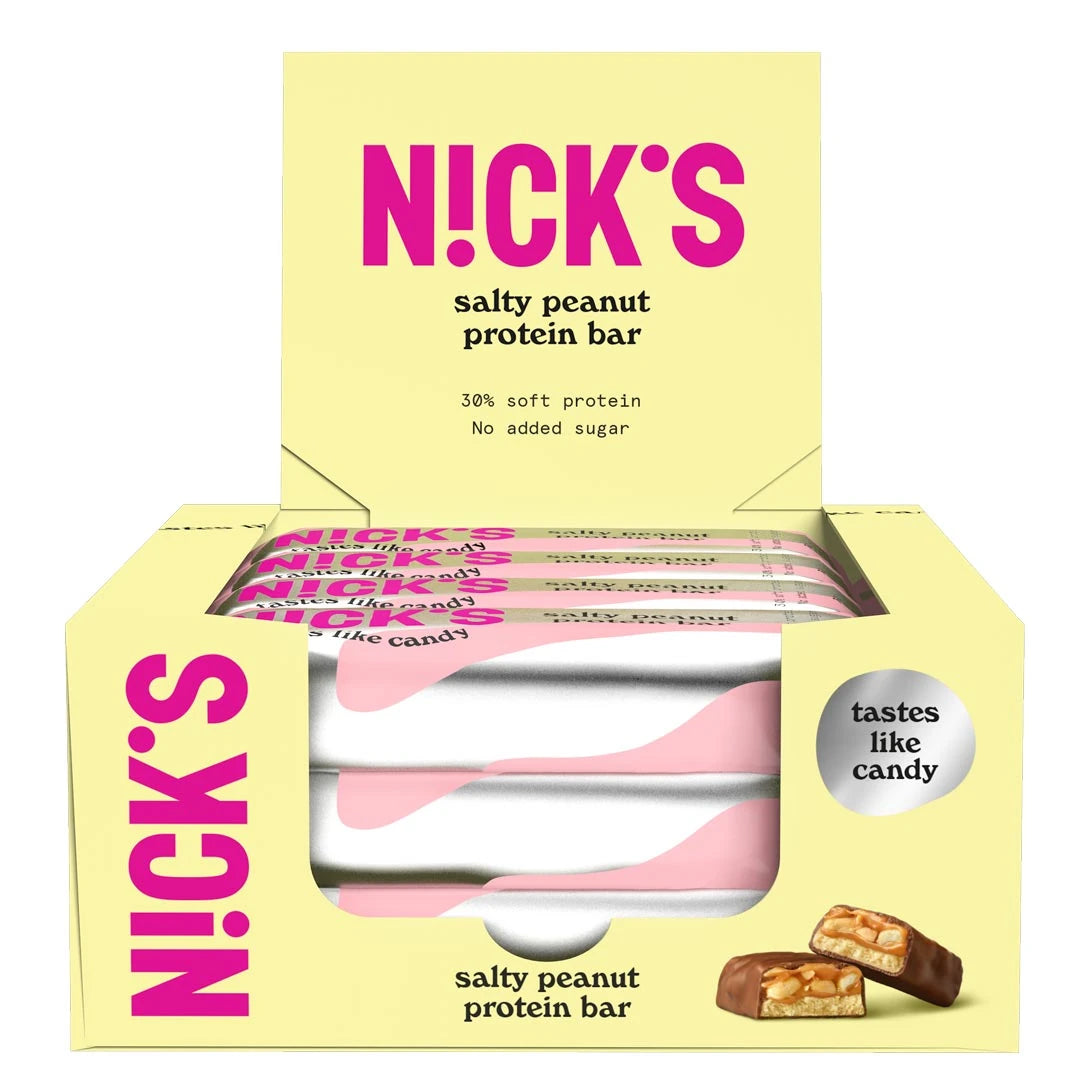 12 x NICKS Soft bar 50 g Salty Peanut SUPER DEAL i en lysegul eske fylt med proteinbarer i rosa og hvite omslag.