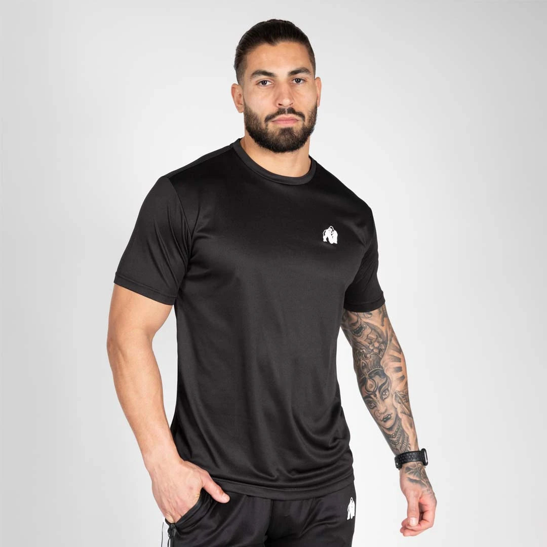 Gorilla Wear Fargo T-Shirt Black, en svart treningstrøye i luftig polyester med hvit logo, båret av en modell., bilde 2 av 2