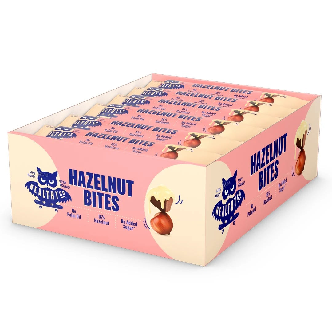 18 x HealthyCo Hazelnut Bites 21 g i en lysegul og rosa displayeske fylt med matchende sjokoladebiter., bilde 1 av 1