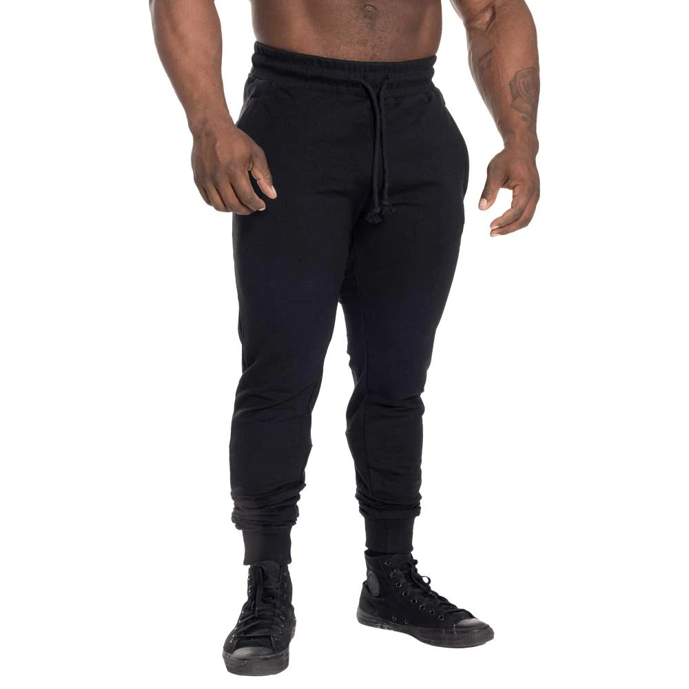 GASP Tapered Joggers Black, svarte treningsbukser med avsmalnende passform og snøring i midjen, båret av en modell., bilde 2 av 2