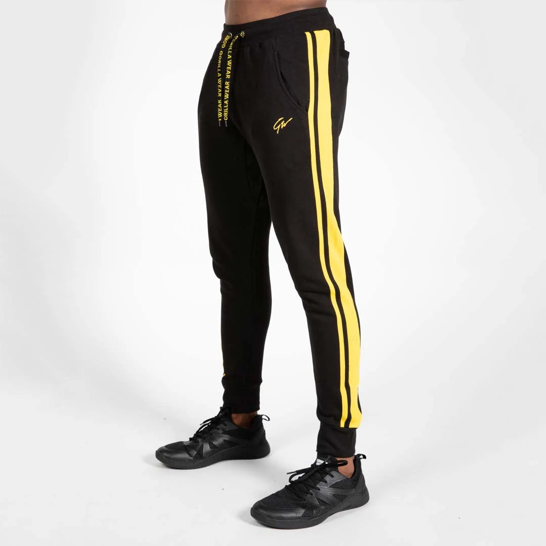 Gorilla Wear Banks Pants Black/Yellow er svarte treningsbukser med gule striper, snorer med tekst og sportslig passform., bilde 5 av 8
