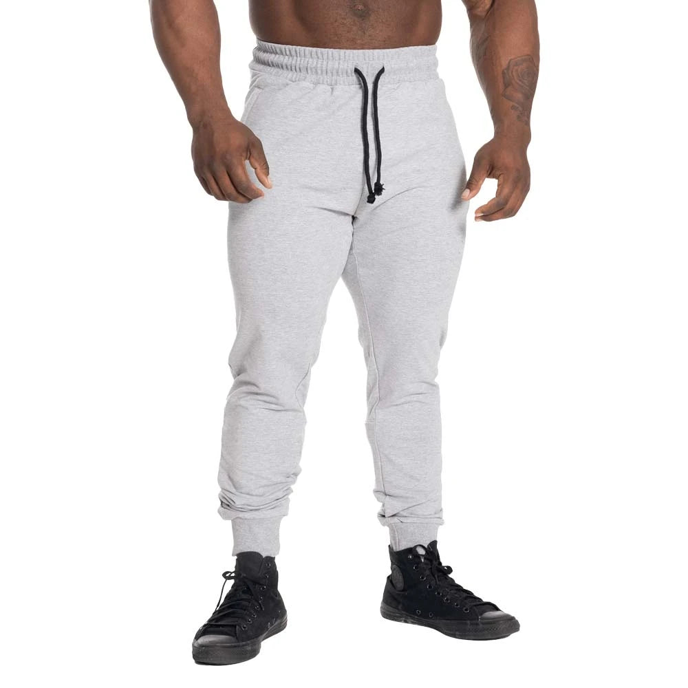 GASP Tapered Joggers Light Grey Melange er lysegrå treningsbukser med avsmalnende passform og svart snøring.