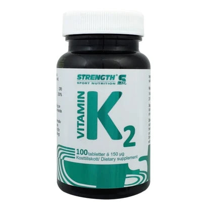 Strength Vitamin K2 100 caps i en svart plastboks med hvitt lokk og grønn tekst på etiketten.