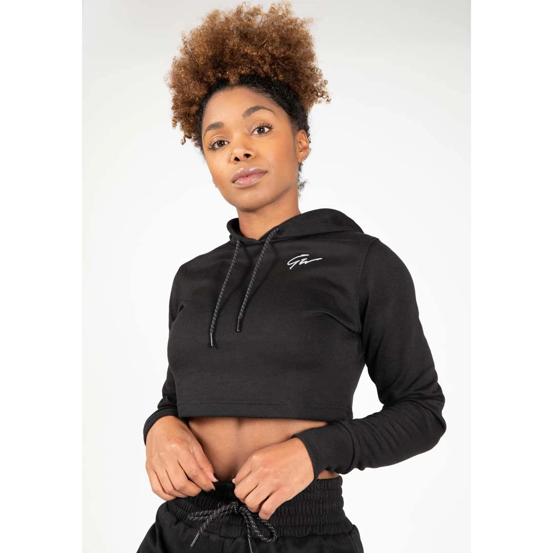 Gorilla Wear Pixley Crop Top Hoodie Black, svart croppet hettegenser i myk bomullsblanding med hvit logo på en modell., bilde 1 av 5