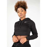 Gorilla Wear Pixley Crop Top Hoodie Black, svart croppad hoodie i mjuk bomullsblandning med vit logga på en modell.