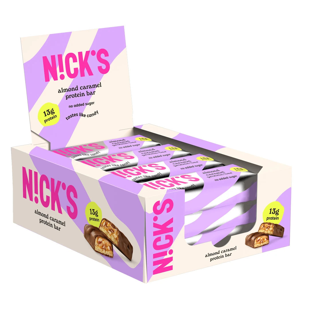 12 x NICKS Soft bar 50 g Almond Caramel i en lilla og hvit displayeske med matchende forpakninger.