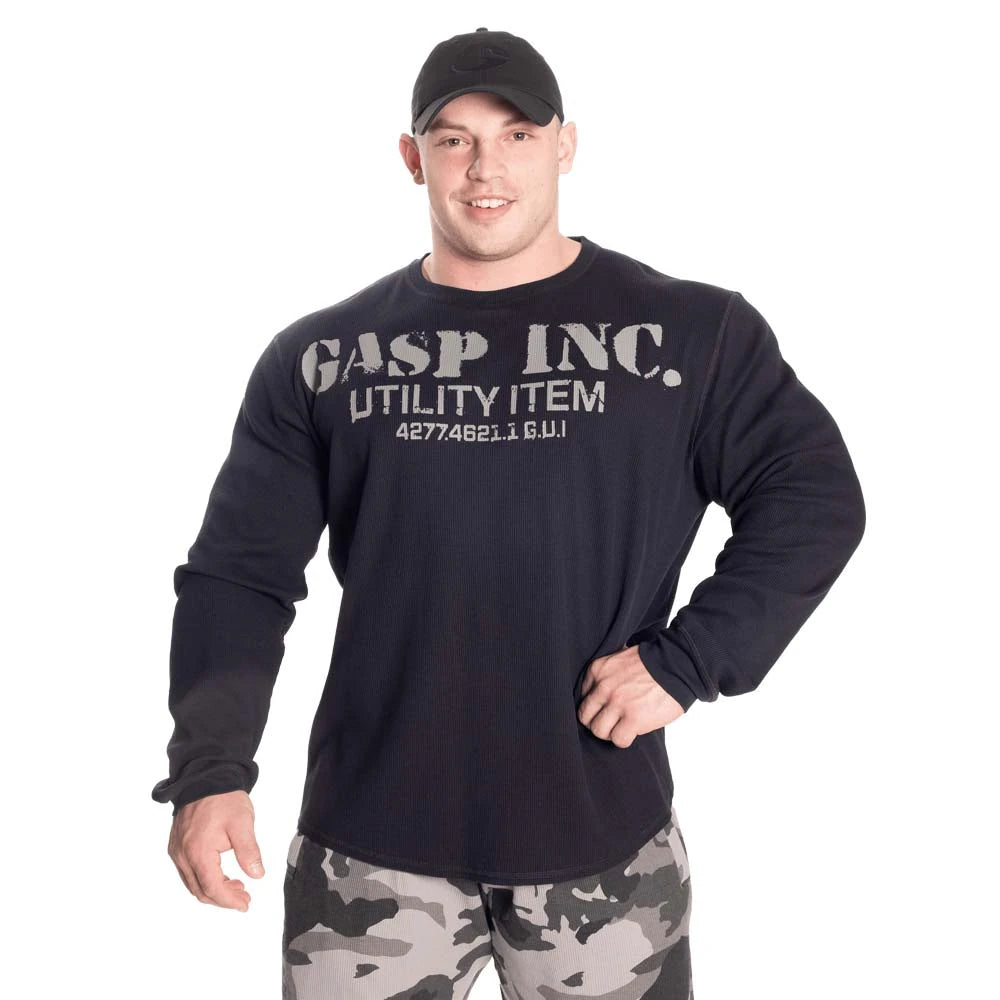 GASP Thermal Gym Sweater Asphalt, en mørkegrå treningstrøye med stort brysttrykk båret av en mannlig modell.